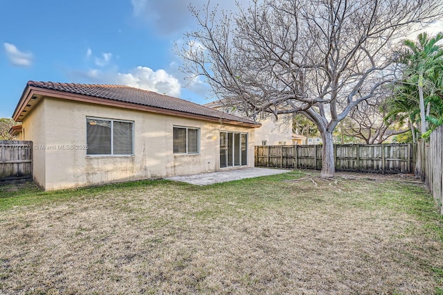 8857 SW 222nd Ter, Cutler Bay, FL 33190 - rear view of property with a tiled roof, a patio area, a fenced backyard, a yard, and stucco siding