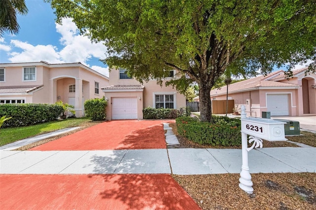 view of front of home featuring driveway, a tile roof, fence, an attached garage, and stucco siding
