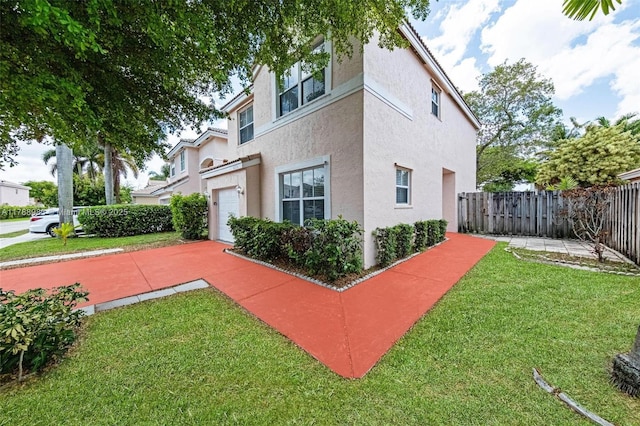 view of home's exterior featuring a yard, a garage, fence, and stucco siding