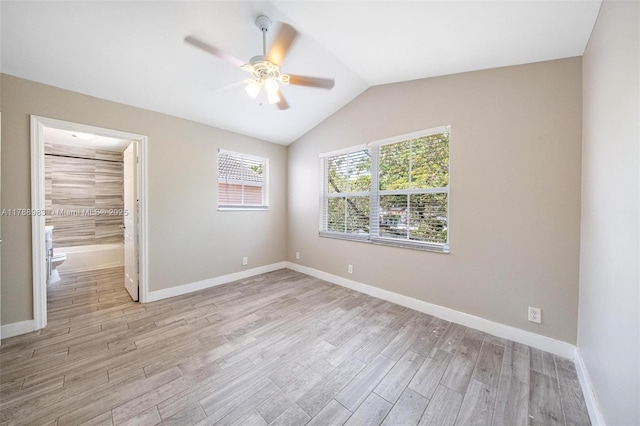 unfurnished bedroom featuring ceiling fan, baseboards, vaulted ceiling, and light wood-style flooring