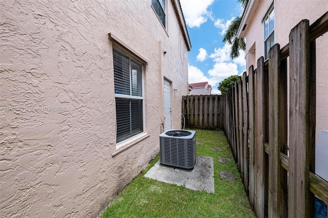 exterior space with central air condition unit and fence
