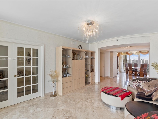living area with ornamental molding, marble finish floor, and a chandelier