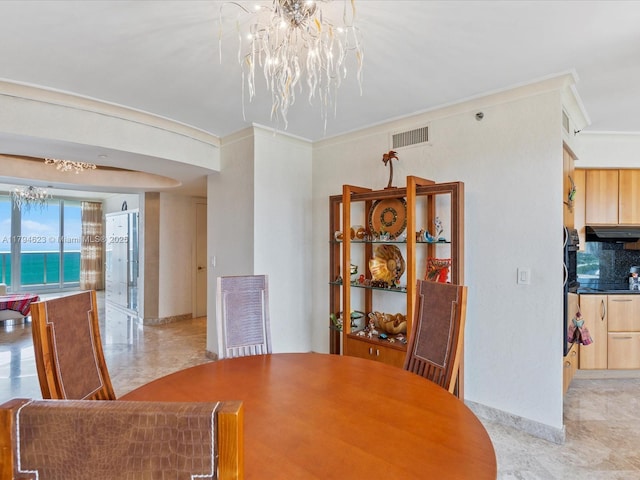 dining room featuring crown molding, baseboards, an inviting chandelier, and visible vents