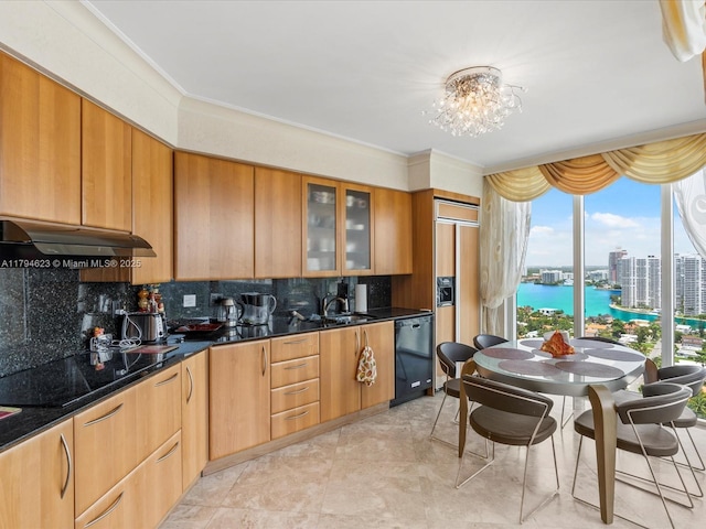 kitchen featuring an inviting chandelier, backsplash, under cabinet range hood, glass insert cabinets, and black appliances