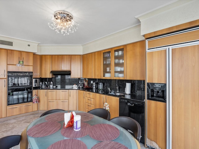 kitchen featuring dark countertops, a sink, under cabinet range hood, visible vents, and black appliances