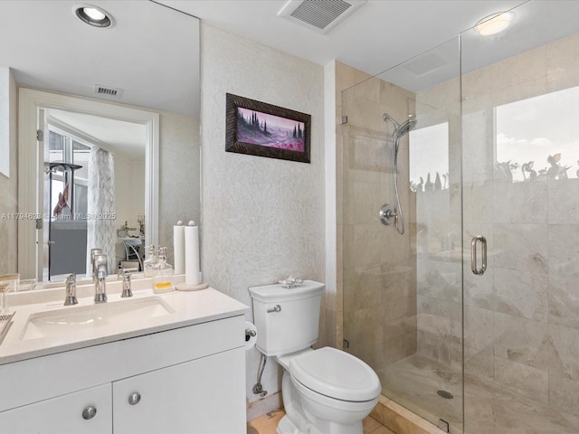 bathroom with a textured wall, vanity, toilet, a shower stall, and visible vents