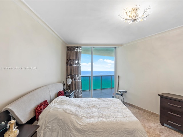 bedroom featuring a water view, ornamental molding, access to outside, and expansive windows