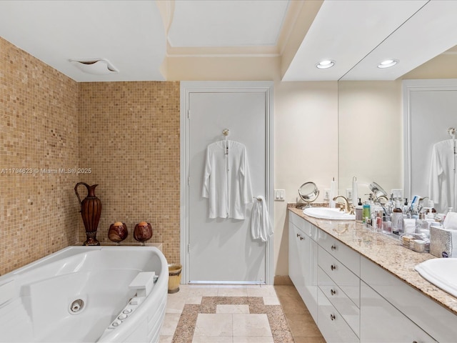 full bath featuring tile patterned flooring, double vanity, a tub with jets, recessed lighting, and a sink