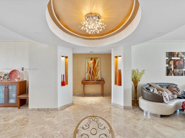 hallway featuring baseboards, marble finish floor, and a chandelier
