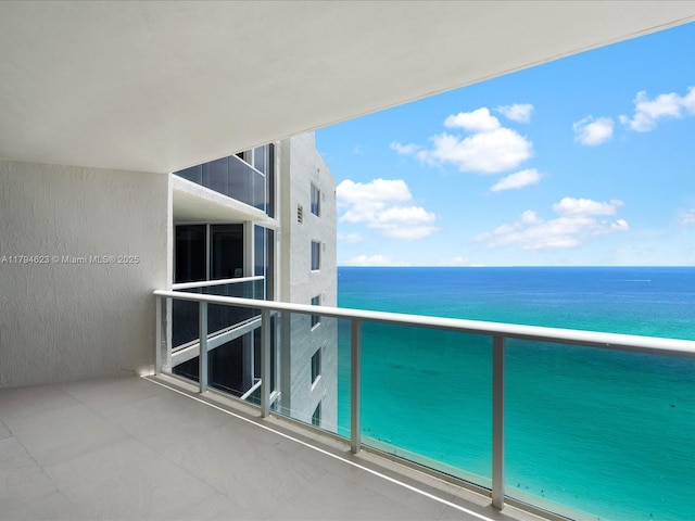balcony featuring a water view and a beach view