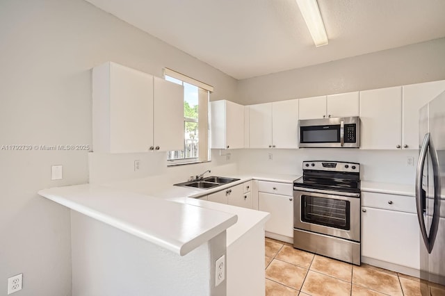 kitchen with stainless steel appliances, white cabinetry, a sink, and a peninsula