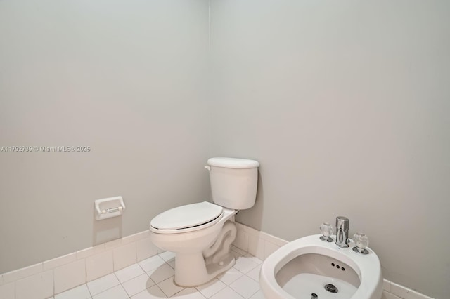 half bath with tile patterned flooring, a bidet, and toilet