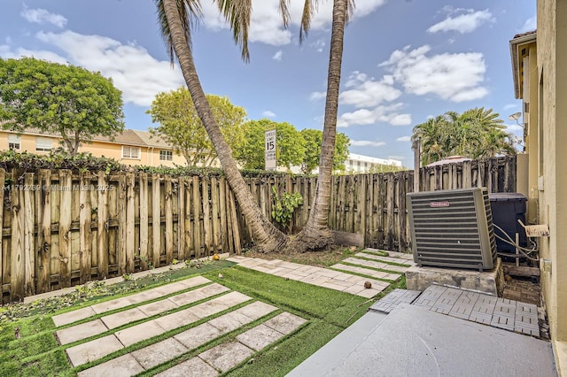 view of yard with central AC unit, a patio area, and a fenced backyard