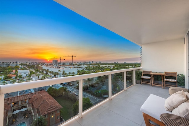 balcony at dusk featuring a view of city