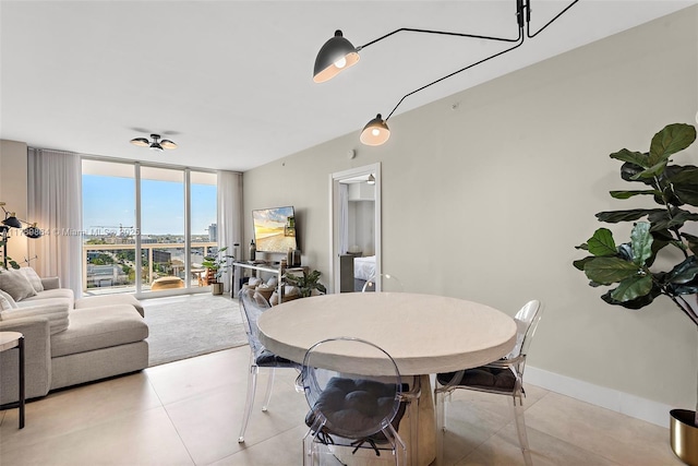 dining space featuring expansive windows, baseboards, and light tile patterned floors