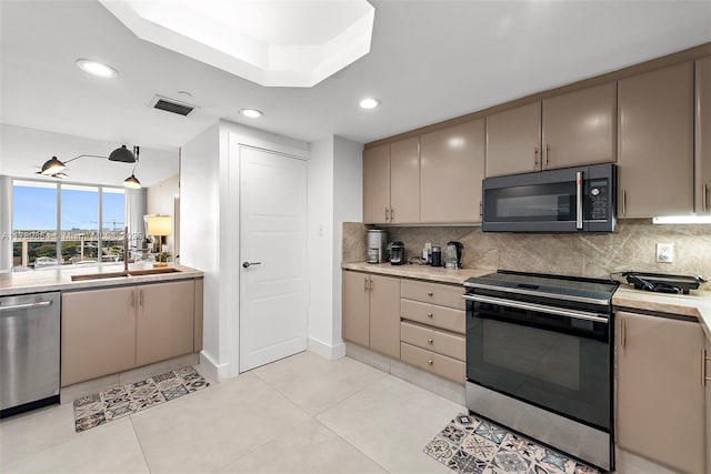 kitchen with visible vents, stainless steel dishwasher, black microwave, range with electric stovetop, and a sink