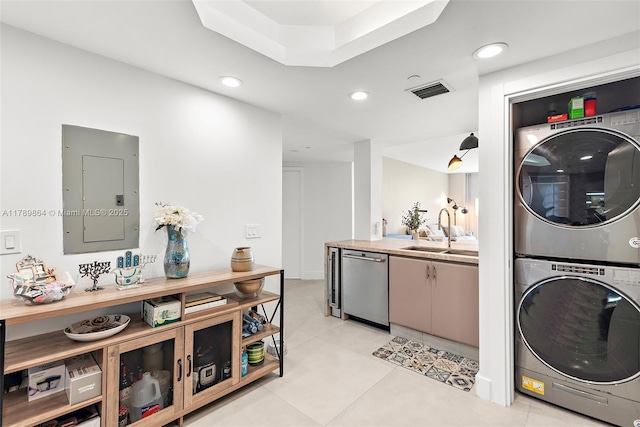 laundry room with electric panel, laundry area, stacked washer and dryer, a sink, and light tile patterned floors