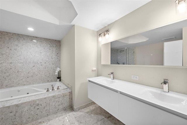 bathroom featuring a sink, baseboards, a tub with jets, and double vanity