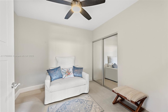 sitting room with baseboards and ceiling fan