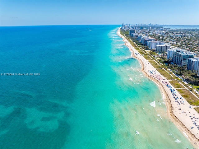 drone / aerial view with a water view, a city view, and a beach view