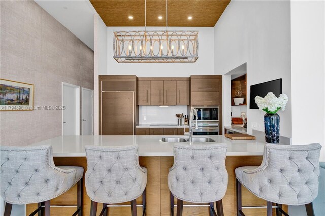 465 Brickell Ave Unit 2801, Miami, FL 33131 - kitchen featuring built in appliances, light countertops, and a towering ceiling