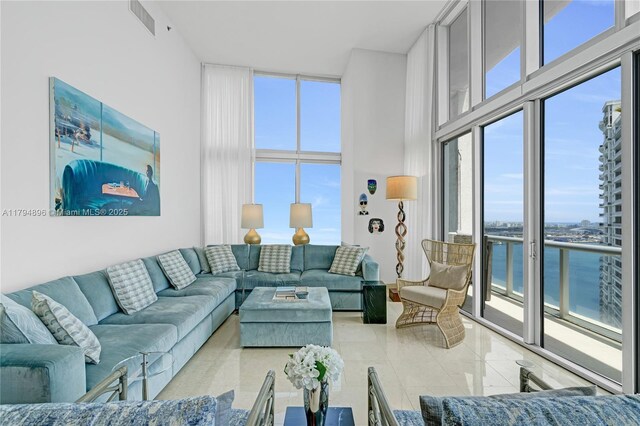 465 Brickell Ave Unit 2801, Miami, FL 33131 - tiled living room featuring a water view, visible vents, and a towering ceiling