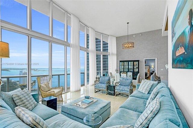 465 Brickell Ave Unit 2801, Miami, FL 33131 - tiled living area with a water view, a notable chandelier, expansive windows, and a towering ceiling