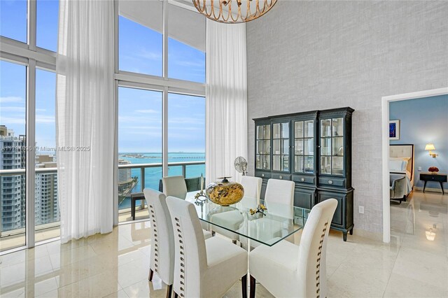 465 Brickell Ave Unit 2801, Miami, FL 33131 - dining area featuring a water view, a high ceiling, a chandelier, and tile patterned flooring