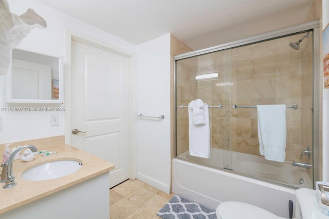 full bath with toilet, bath / shower combo with glass door, and vanity