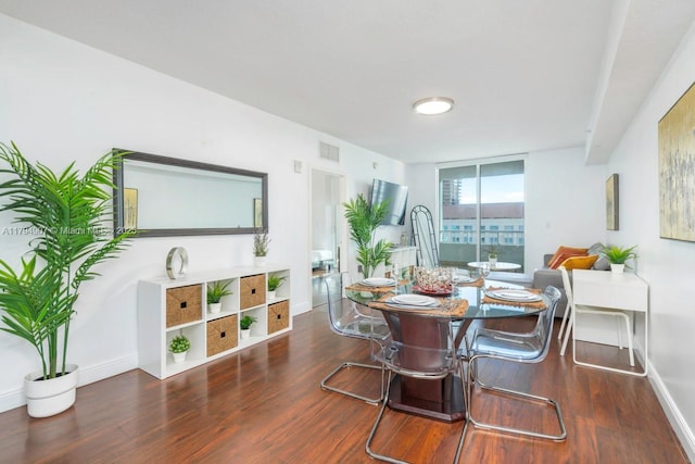 dining room featuring baseboards, floor to ceiling windows, wood finished floors, and visible vents
