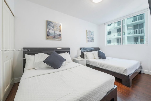 bedroom with baseboards, a closet, and wood finished floors