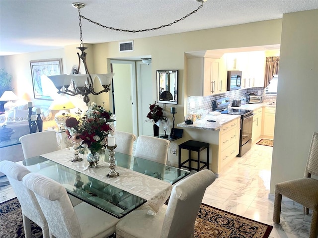 dining space with a textured ceiling, visible vents, marble finish floor, and a toaster
