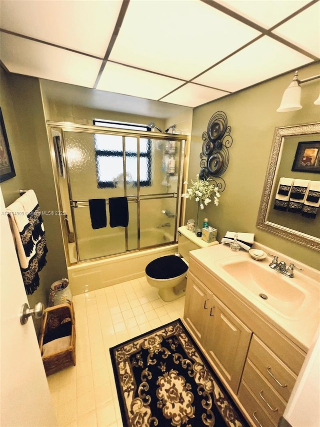 full bathroom featuring vanity, enclosed tub / shower combo, tile patterned floors, and toilet