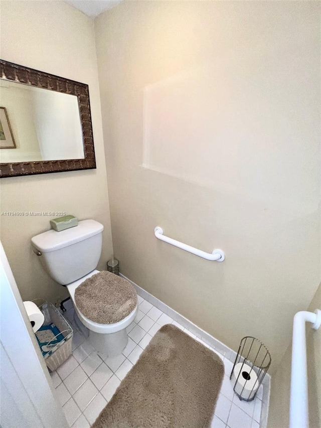 bathroom featuring baseboards, tile patterned flooring, and toilet