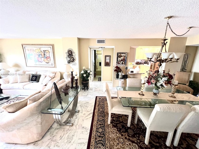 dining room with a textured ceiling, visible vents, and marble finish floor