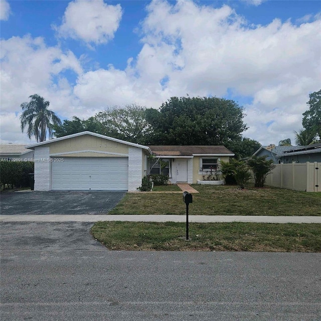 single story home featuring an attached garage, fence, driveway, and a front lawn