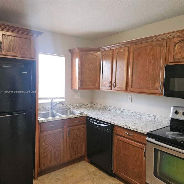 kitchen with a sink, light countertops, black appliances, and brown cabinets
