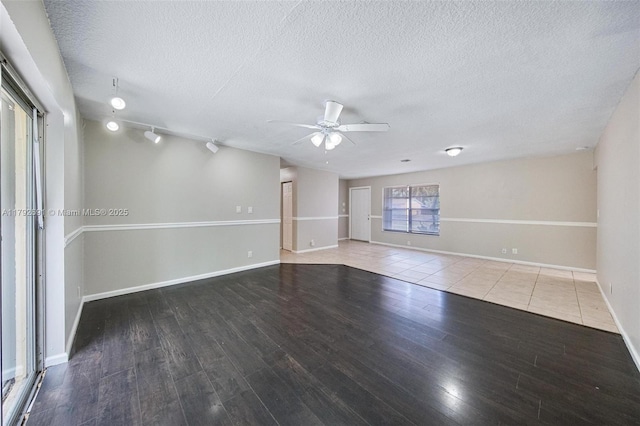 spare room with baseboards, a ceiling fan, a textured ceiling, and wood finished floors