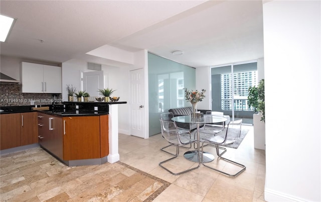 170 SE 14th St Unit 2708, Miami, FL 33131 - kitchen with visible vents, decorative backsplash, a peninsula, dark countertops, and floor to ceiling windows