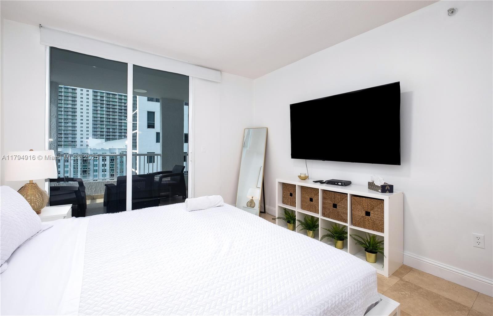170 SE 14th St Unit 2708, Miami, FL 33131 - bedroom featuring baseboards and a wall of windows