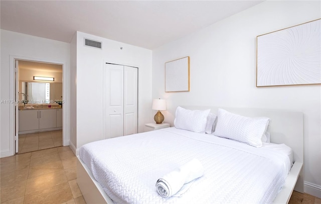 170 SE 14th St Unit 2708, Miami, FL 33131 - bedroom with a closet, visible vents, baseboards, light tile patterned floors, and ensuite bath