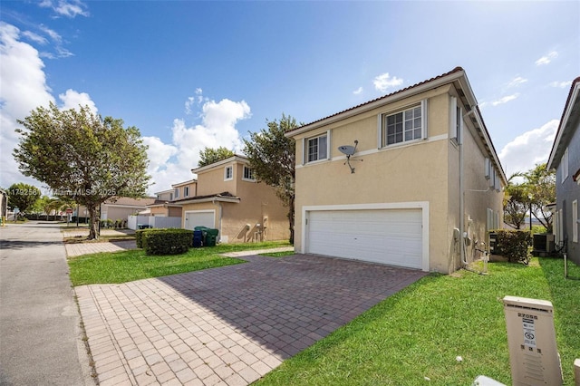 27056 SW 140th Pl, Homestead, FL 33032 - view of front facade featuring a garage, stucco siding, decorative driveway, and a front lawn