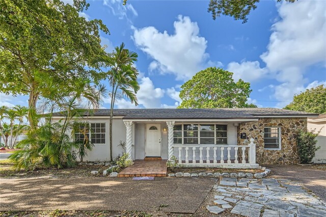7740 Shalimar St, Miramar, FL 33023 - single story home with roof with shingles, covered porch, and stone siding