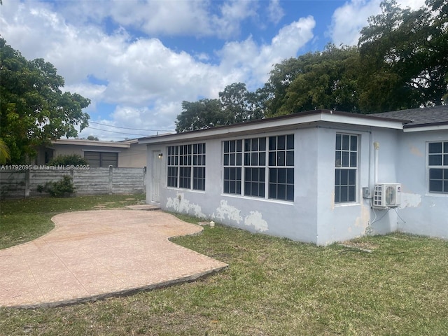 view of property exterior with a lawn, ac unit, fence, a patio, and stucco siding