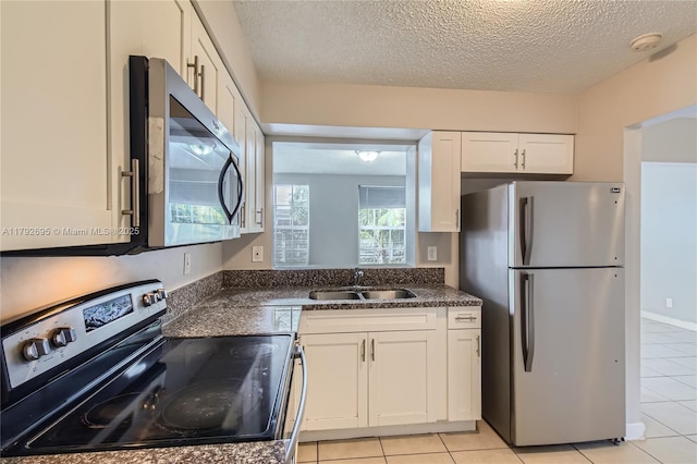7740 Shalimar St, Miramar, FL 33023 - kitchen with white cabinets, appliances with stainless steel finishes, a sink, a textured ceiling, and light tile patterned floors