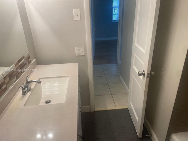 bathroom with baseboards, tile patterned flooring, and vanity