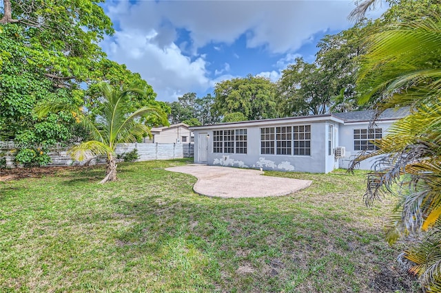 7740 Shalimar St, Miramar, FL 33023 - rear view of house featuring a lawn, fence, stucco siding, and a patio area