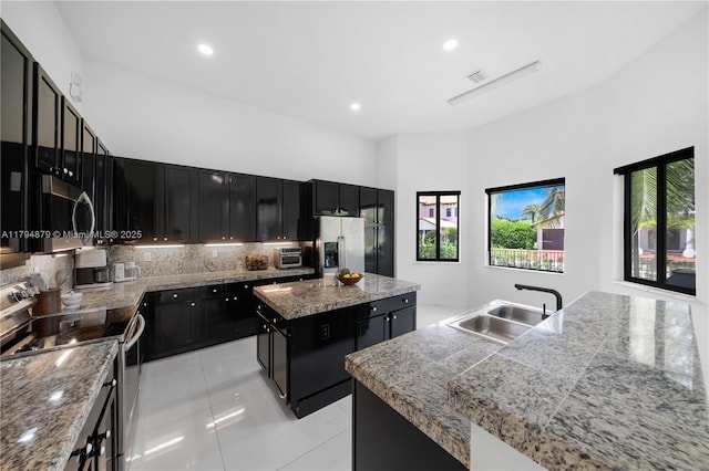 7745 SW 188th Ter, Cutler Bay, FL 33157 - kitchen with dark cabinetry, stainless steel appliances, a sink, and a kitchen island