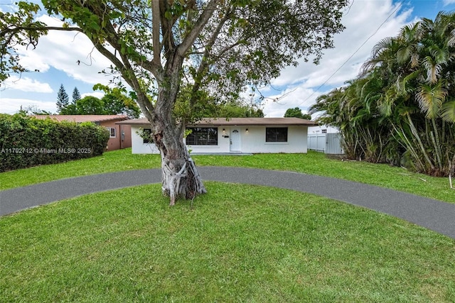 7817 NE Madeira St, Miramar, FL 33023 - ranch-style house featuring fence, stucco siding, driveway, and a front yard