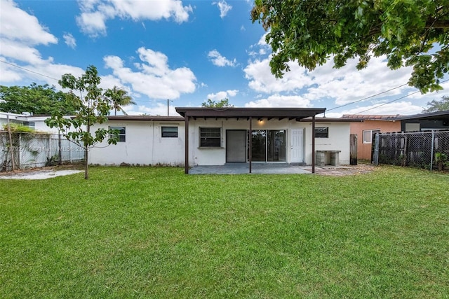 7817 NE Madeira St, Miramar, FL 33023 - rear view of house with a lawn, fence, stucco siding, and a patio
